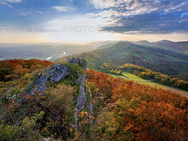 View of an autumnal forest from the Gisliflue, behind the Jura foothills with Wasserfluh and