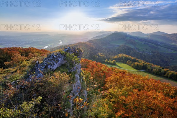 View from the Gisliflue of an autumn-colored forest, behind the Jurassic foothills with water fluh