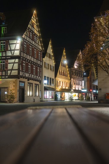 Illuminated half-timbered houses line the Old Town Street at night and create a festive atmosphere,