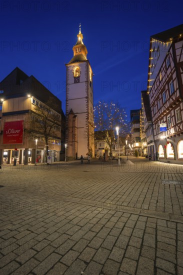 Bell tower of a church illuminated at night, surrounded by half-timbered houses, Nagold, Calw