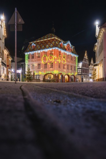 Night view of a historic building illuminated with a colorful light projection, Nagold, Calw
