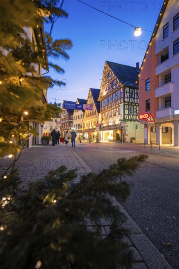 City street with illuminated half-timbered houses and festive lighting, walkers, Nagold, Calw