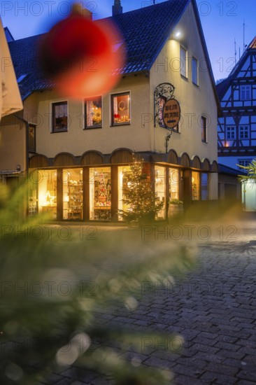Commercial building with Christmas decoration and half-timbering at dusk, Nagold, Calw district,