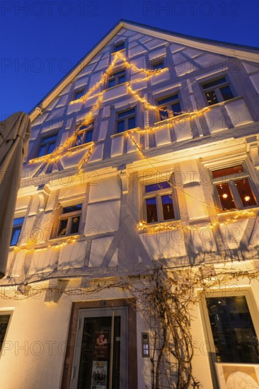 Fairy lights in tree silhouette on the façade of a furnished house, Nagold, Calw district, Black