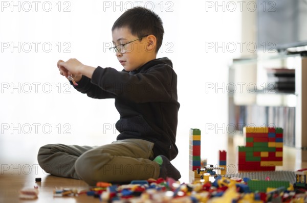 Boy, 6 years, glasses, multi-ethnic, plays with Lego, concentrates, constructs, builds, Stuttgart,