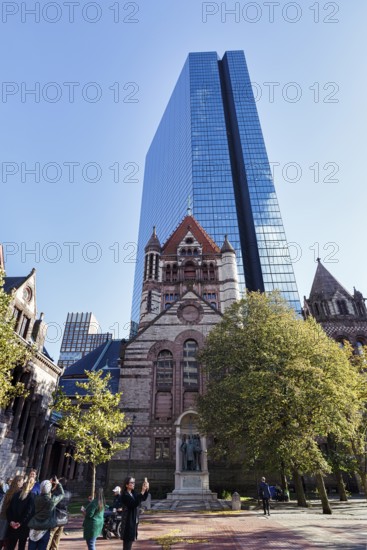 Tourist group photographs Trinity Church, glass façade of John Hancock Tower, various architectural