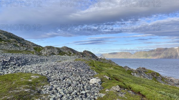 Rocky coastal landscape with sea views and a peaceful atmosphere in cloudy skies on Syltejjord on