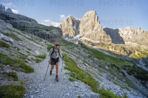 Female mountaineer in front of picturesque mountain landscape in the morning, Rifugio Ai Brentei