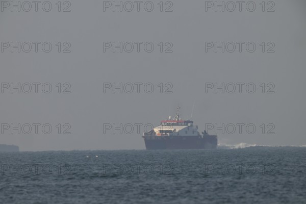 Large ship Catamaran feeder ship for offshore workers at wind farms near Heligoland sails on open