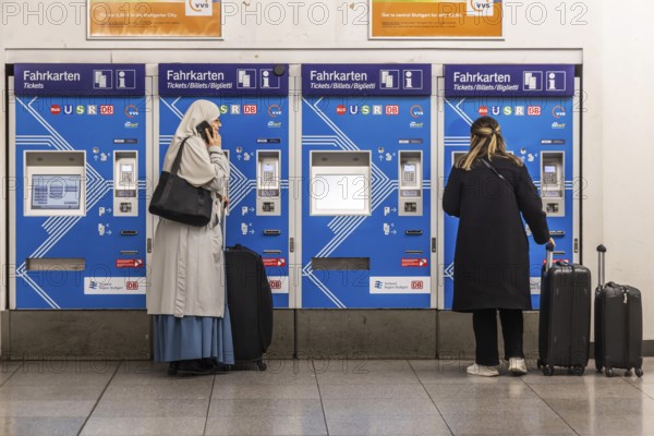 Ticket vending machine at Stuttgart Airport with travelers buying a public transport ticket.