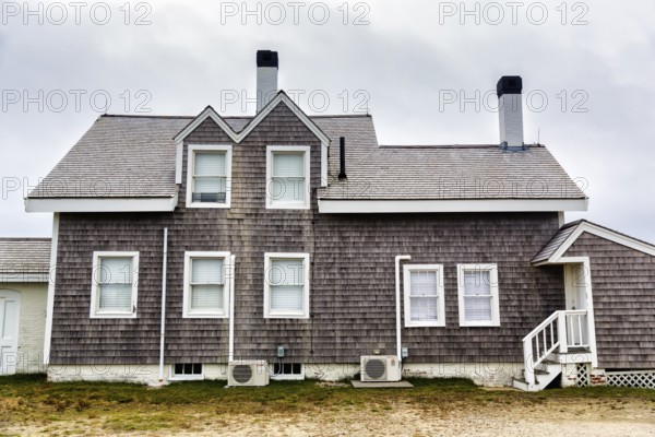 House with wooden shingles, typical architectural style, storm protection window, Highland Light,