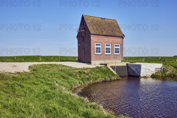 Hunnebüllerkoog, Hunnebüller Sielzug, pumping plant, façade with windows, pointed roof with red