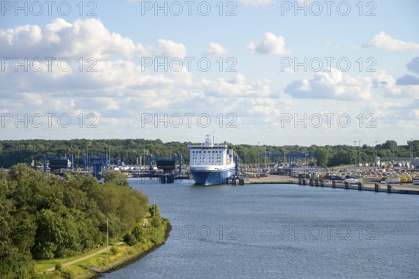Scandinavienkai Tavemünde with large Finnlines ferry in port, surrounded by water and fluffy