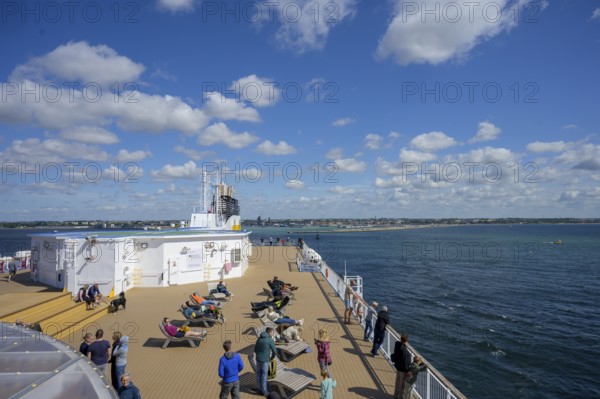 People relax on a TT-Line ship deck with a view of the sea under a blue sky, Trelleborg, Skåne län,