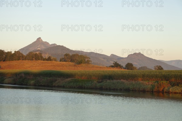 Sunrise light illuminating Mount Warning and surrounding farmland with cultivated cane fields