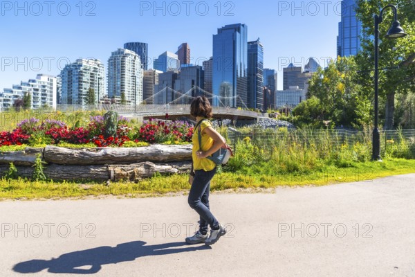 Young woman enjoying a sunny summer day strolling along the scenic east village riverwalk pathway,