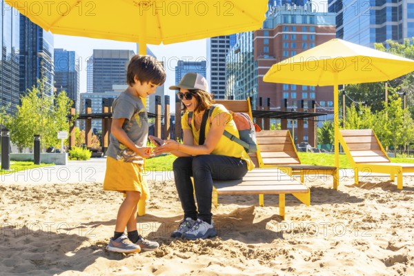 Mother and her son are spending quality time together at an urban beach in calgary, sheltered by