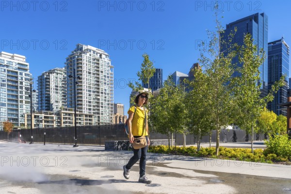Tourist wearing a yellow t shirt and a hat is enjoying a walk in calgary's east village