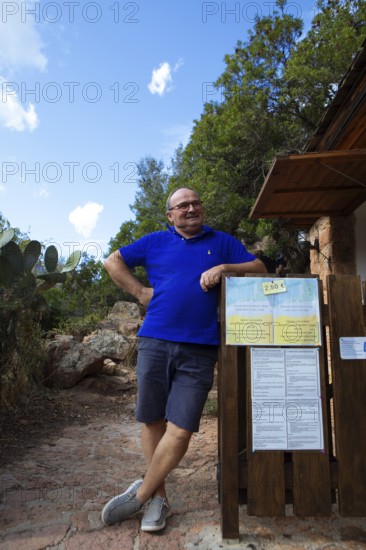 Corsican man, 67 years old, checks the entrance to the Genoese Tower of Porto, Ota, west coast of
