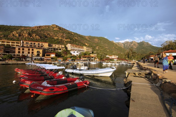 Colourful boats in Port de Porto or Port on the Porto River, in the background the Capu d'Orto