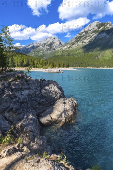 Breathtaking turquoise waters of lake minnewanka reflecting majestic rocky mountains under a
