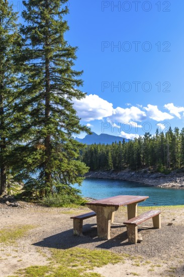 Turquoise waters of lake minnewanka sparkle under a bright blue sky, inviting visitors to enjoy a