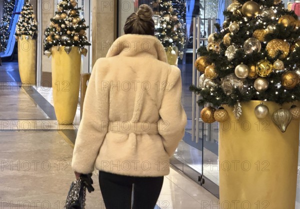 Luxuriously dressed woman in a Christmassy decorated passage in the KÖ Gallery, Düsseldorf, North