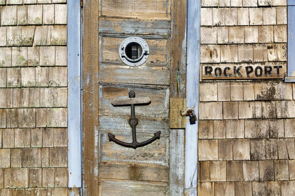Maritime façade detail in harbor, door with anchor, typical wooden shingles and inscription,