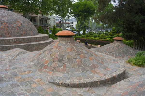 Dome formations and green surroundings with classic brick elements, sulfur baths, Abanotubani spa