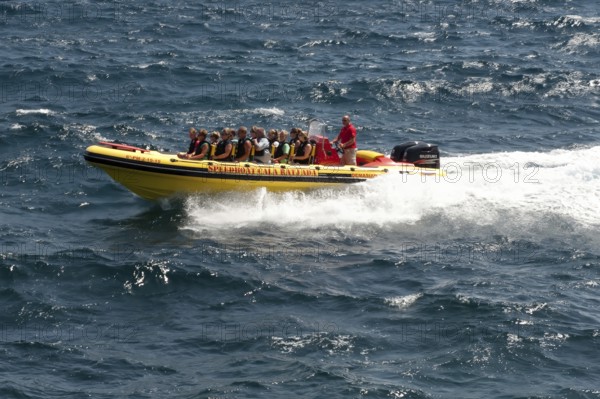 Speedboat speedboat with tourists riding on board glides through waves in the Mediterranean Sea,