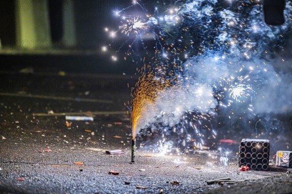 Burnt off fireworks are lying on the street, firecracker smoke produces smoke. New Year's night on