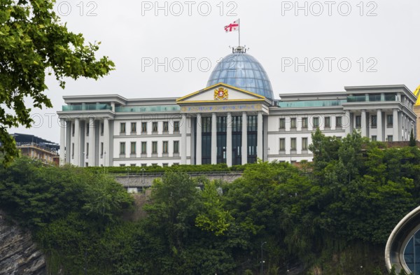 Large government building with dome and flag on a green hill, state palace for ceremonies, Avlabari