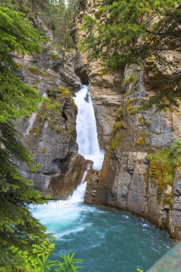 Turquoise water flows through johnston canyon in banff national park, alberta, canada, creating a