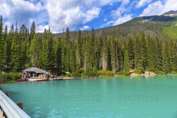 Emerald lake lodge and surrounding pine trees reflecting in the turquoise waters of emerald lake,