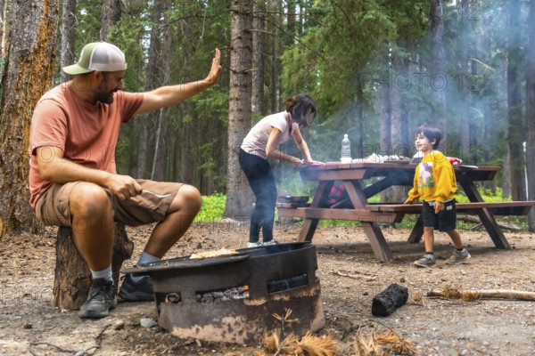 Family camping and grilling while bonding in the breathtaking scenery of banff national park, with