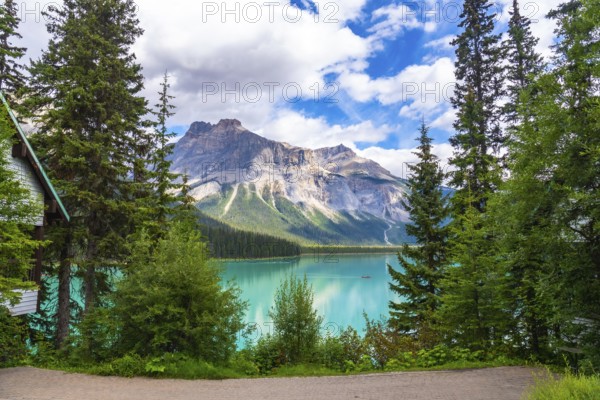 Emerald lake reflecting the majestic mount burgess under a cloudy sky, surrounded by lush