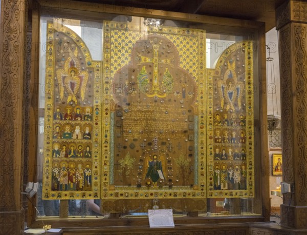 Icons and sacred symbols in an intricately designed glass display case in a church, Sameba