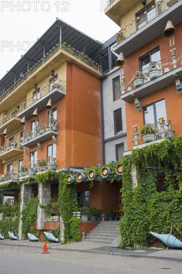 Multi-storey residential building with colorful facades, balconies and lots of greenery, Brim