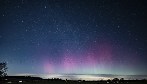 Glowing polar lights in shades of purple and green under a clear starry sky, EXPO Observatory