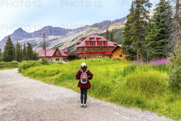 Female tourist walking along a gravel path toward the historic num ti jah lodge at bow lake,