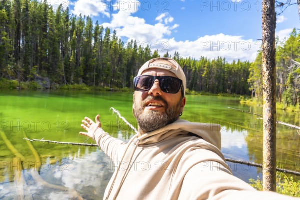 Happy tourist taking a selfie with outstretched arms, embracing the stunning turquoise waters of