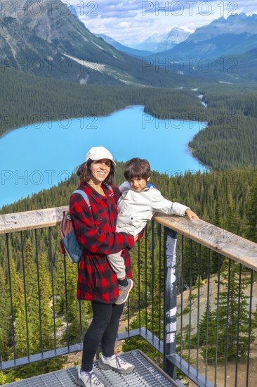 Mother holding her son while admiring the stunning panoramic view of vibrant turquoise waters at