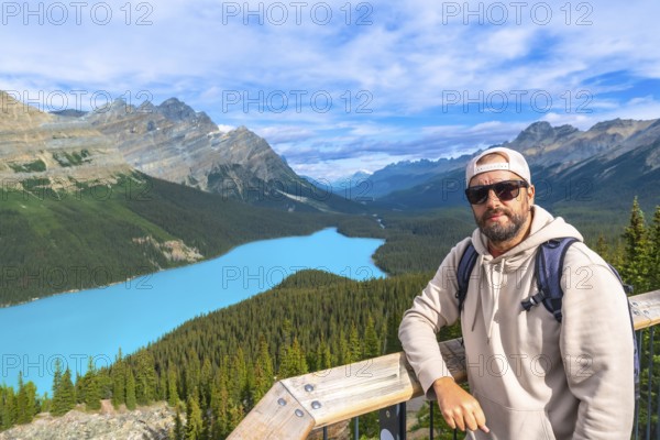 Backpacker standing on a scenic viewpoint, enjoying the stunning turquoise waters of peyto lake and