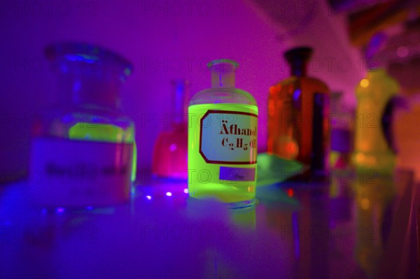 Glowing bottles in an escape room chemical laboratory with neon light create a mystical atmosphere,