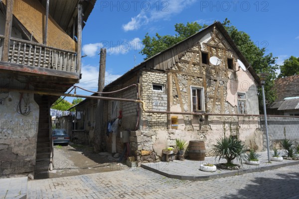 Traditional half-timbered stone house with a veranda in a quiet village street, traditional German