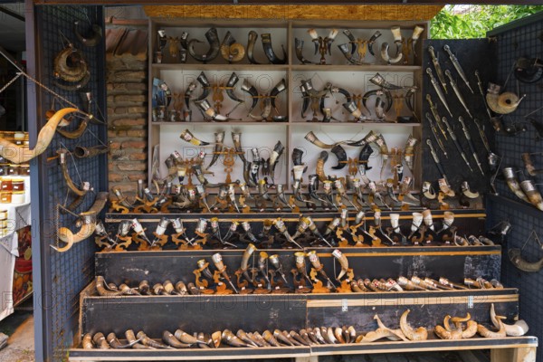 Souvenir stand with a large collection of traditional horns displayed on wooden shelves, Mtskheta,