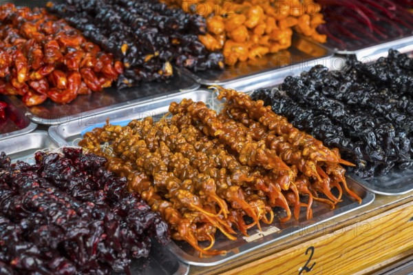Plates of colorful Georgian sweets made from fruits and nuts at a market stand, Churchkhela,