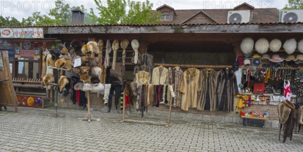 Market stall with fur hats and coats surrounded by souvenirs and traditional style, Mtskheta,