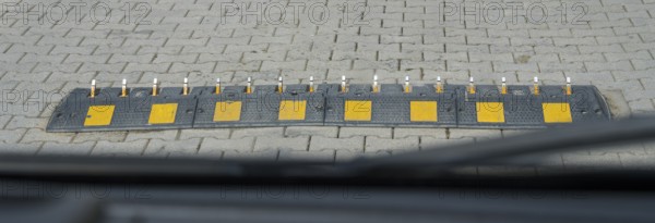 Ground obstruction with yellow markings on a paved road, one-way speed problems with spikes on the