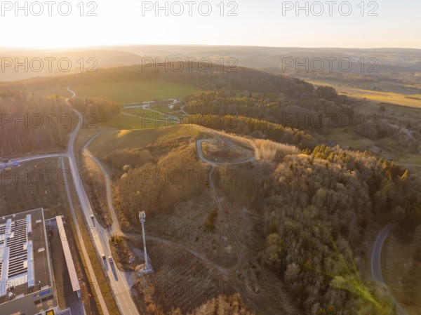 Aerial view of hilly landscape and forest in evening light, future PV building on old deposit,